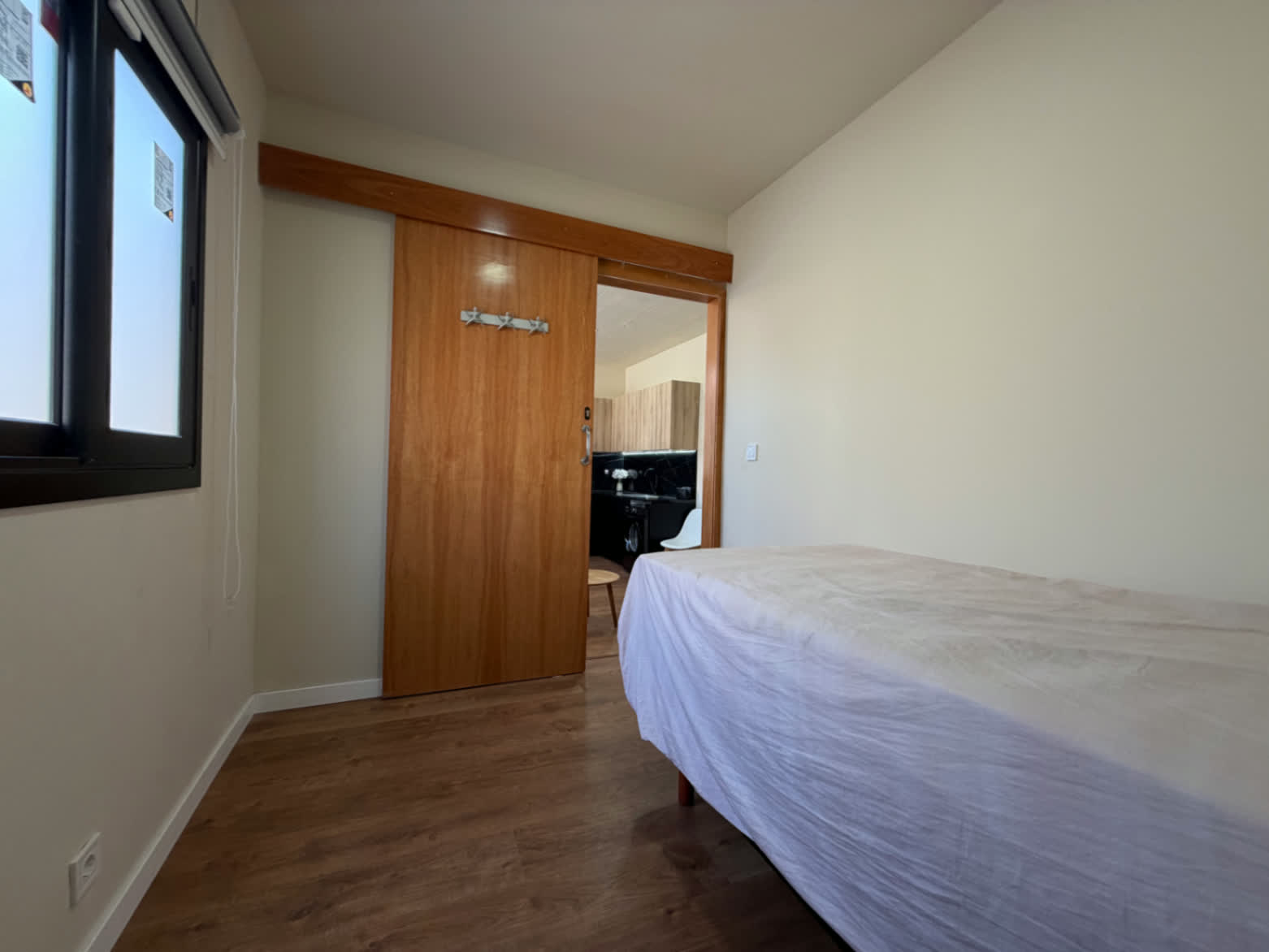 Habitación con puerta corredera de madera y acceso a la zona de día