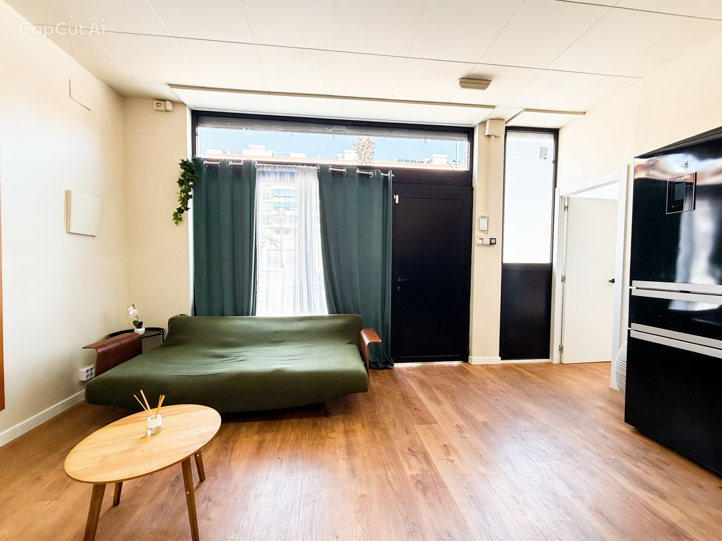 Zona de estar con gran ventanal exterior y entrada a la vivienda