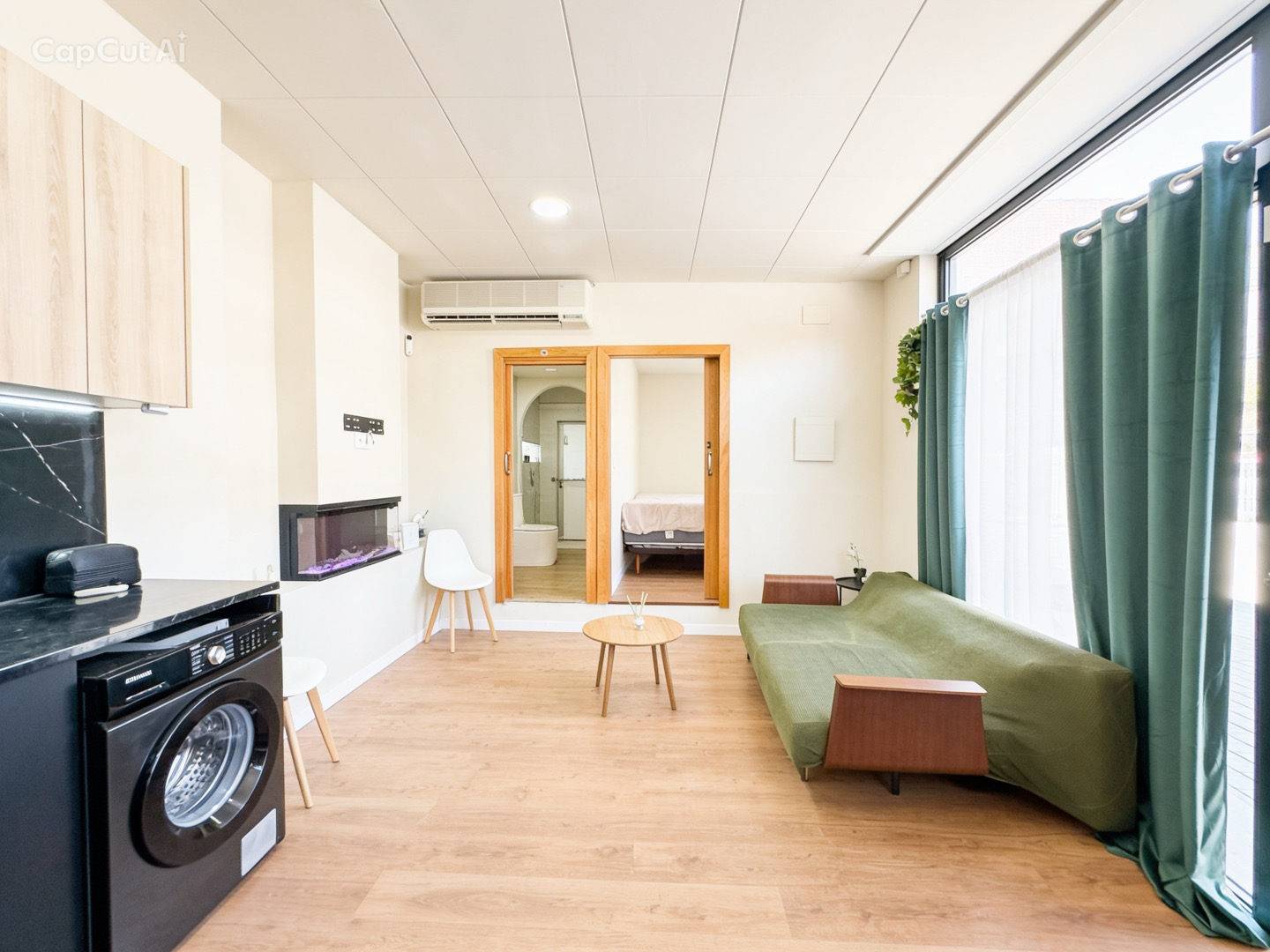 Salón con chimenea eléctrica y acceso a habitación y baño