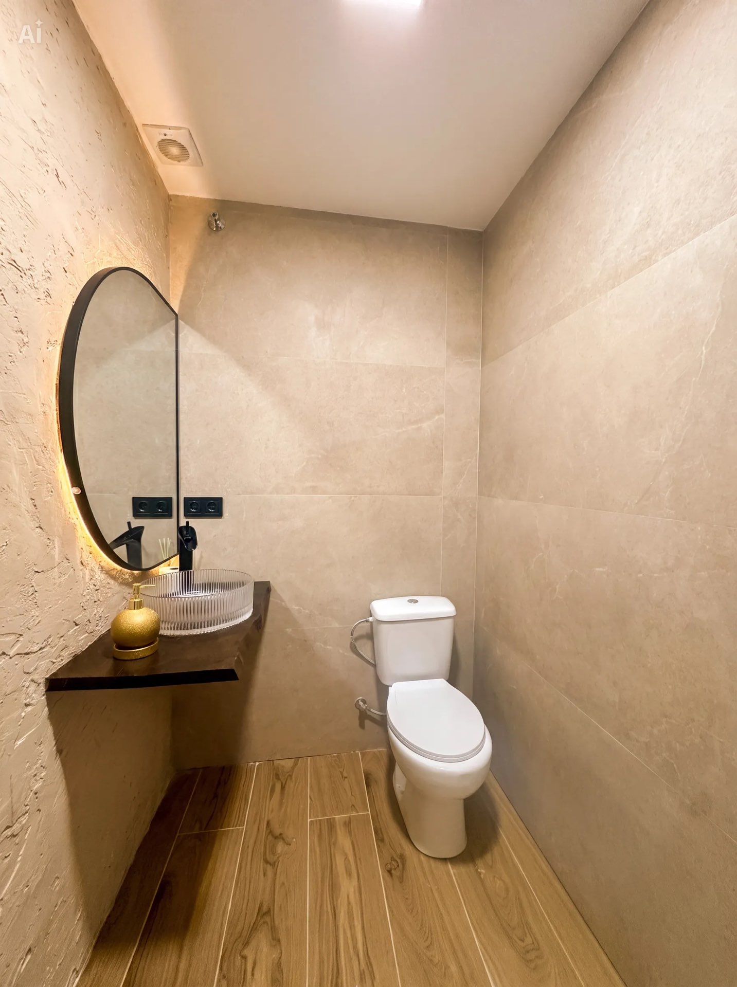 Baño con lavabo, espejo retroiluminado e inodoro
